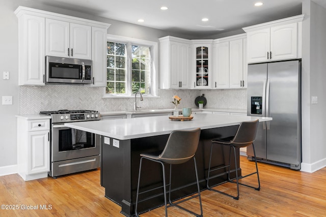 11 Fairview Ln, Halfmoon, NY 12118 - kitchen featuring stainless steel appliances, recessed lighting, white cabinetry, a kitchen breakfast bar, and tasteful backsplash