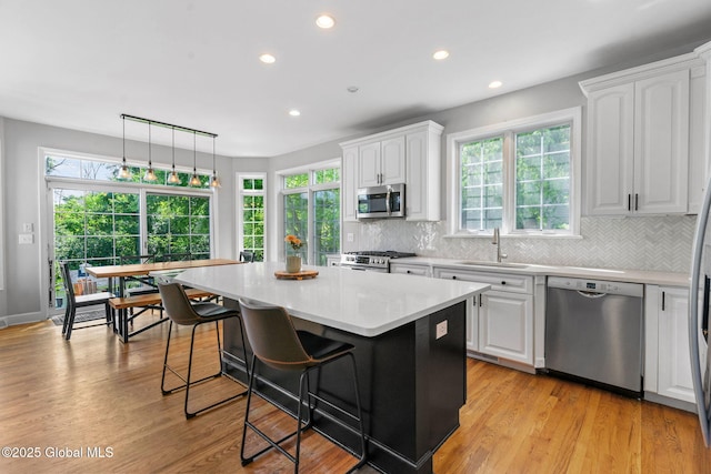 11 Fairview Ln, Halfmoon, NY 12118 - kitchen with appliances with stainless steel finishes, a kitchen island, white cabinetry, decorative backsplash, and recessed lighting