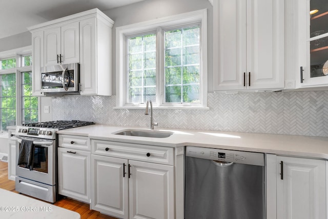 11 Fairview Ln, Halfmoon, NY 12118 - kitchen with appliances with stainless steel finishes, white cabinets, light wood-type flooring, glass insert cabinets, and plenty of natural light