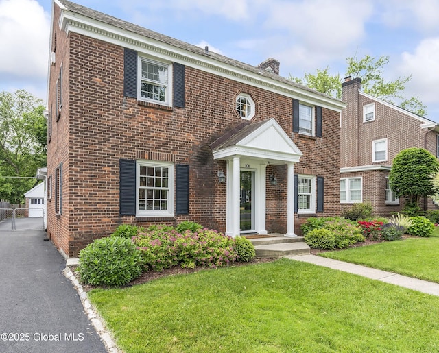 101 Euclid Ave, Albany, NY 12203 - colonial home featuring brick siding, a front lawn, an outbuilding, and a chimney