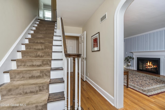101 Euclid Ave, Albany, NY 12203 - staircase featuring wood finished floors, arched walkways, and a lit fireplace