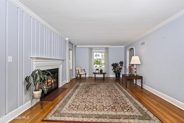101 Euclid Ave, Albany, NY 12203 - living area featuring wood finished floors, a warm lit fireplace, and ornamental molding