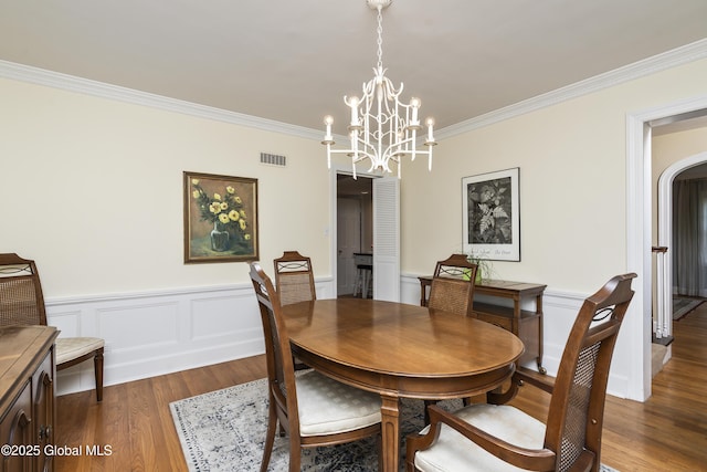 101 Euclid Ave, Albany, NY 12203 - dining room featuring a chandelier, wood finished floors, crown molding, a wainscoted wall, and a decorative wall