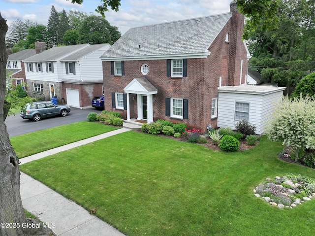 101 Euclid Ave, Albany, NY 12203 - view of front facade with brick siding, asphalt driveway, a front yard, and a chimney