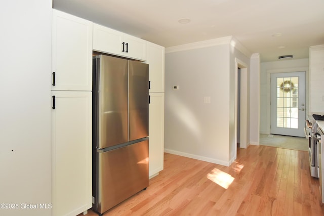 21 Cabot Way, Halfmoon, NY 12065 - kitchen with freestanding refrigerator, white cabinetry, light wood-style floors, and ornamental molding