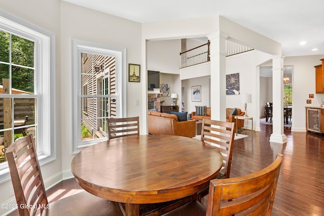 7 Anthony Ln, Saratoga Springs, NY 12866 - dining space featuring ornate columns, beverage cooler, wood finished floors, recessed lighting, and a fireplace