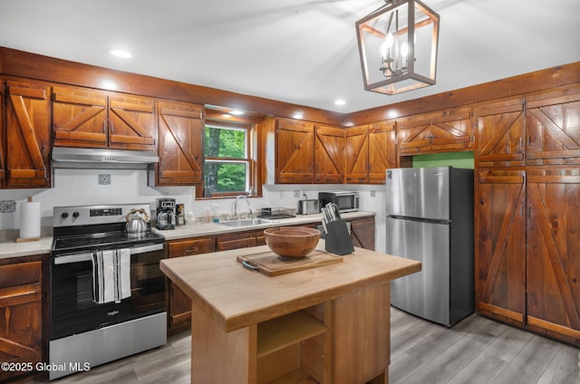 633 Moore Hill Rd, Stephentown, NY 12168 - kitchen featuring appliances with stainless steel finishes, wood counters, under cabinet range hood, light wood finished floors, and backsplash