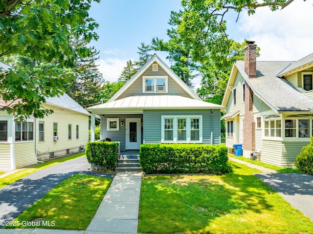 87 Hollywood Ave, Albany, NY 12208 - bungalow featuring a front yard, a standing seam roof, covered porch, a chimney, and a metal roof