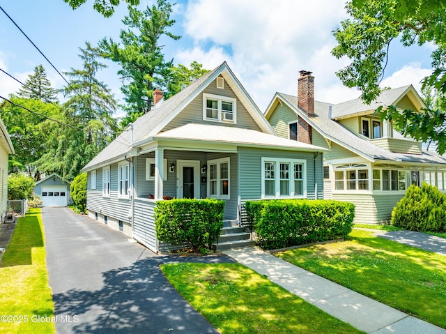 87 Hollywood Ave, Albany, NY 12208 - view of front of home with a garage, an outdoor structure, a front lawn, and covered porch