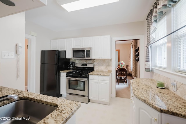 87 Hollywood Ave, Albany, NY 12208 - kitchen featuring stainless steel appliances, tasteful backsplash, light stone countertops, and white cabinets