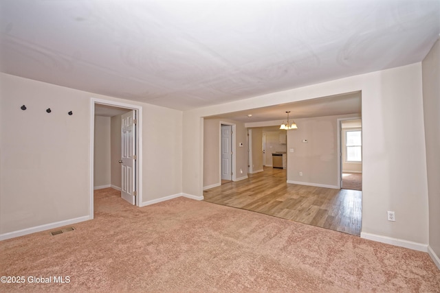 901 Adams St, Rotterdam, NY 12306 - spare room with light carpet and a chandelier