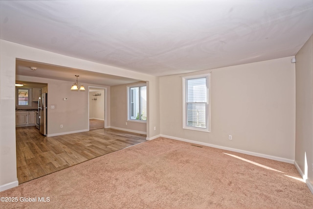 901 Adams St, Rotterdam, NY 12306 - carpeted empty room featuring baseboards and a chandelier