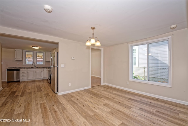 901 Adams St, Rotterdam, NY 12306 - empty room featuring a chandelier, a smoke detector, light wood-type flooring, and healthy amount of natural light