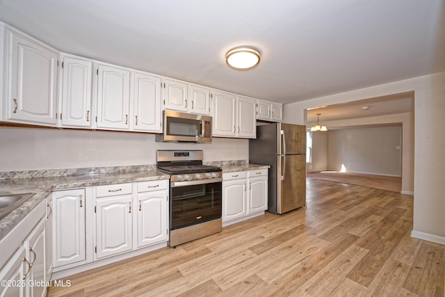 901 Adams St, Rotterdam, NY 12306 - kitchen with stainless steel appliances, a chandelier, white cabinetry, light wood-style floors, and light countertops