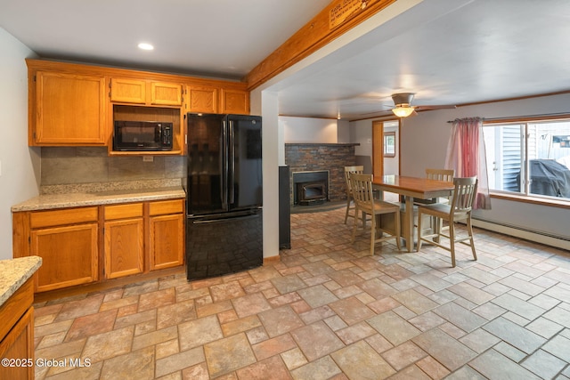 3445 Gari Ln, Guilderland, NY 12303 - kitchen featuring black appliances, ceiling fan, backsplash, brown cabinets, and a wood stove
