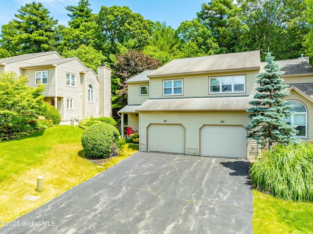 22 Pine Ridge Rd, Stillwater, NY 12866 - view of front of home with asphalt driveway, a garage, a front lawn, and view of scattered trees