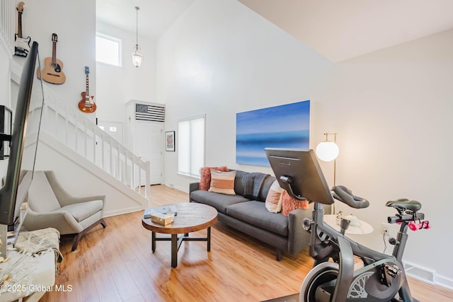 22 Pine Ridge Rd, Stillwater, NY 12866 - living room featuring light wood-type flooring, stairway, and high vaulted ceiling
