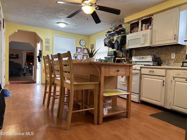 634 State Route 143, Westerlo, NY 12193 - kitchen with white appliances, open shelves, light wood-style floors, a ceiling fan, and white cabinetry