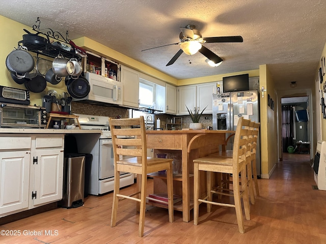 634 State Route 143, Westerlo, NY 12193 - kitchen with white appliances, a textured ceiling, ceiling fan, light wood-type flooring, and white cabinetry