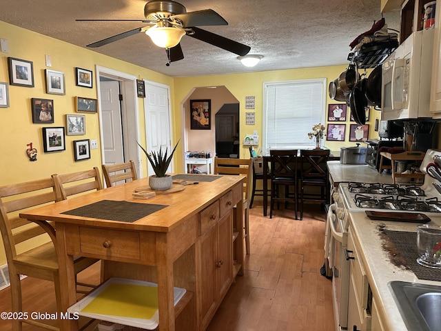 634 State Route 143, Westerlo, NY 12193 - kitchen with white appliances, a textured ceiling, a ceiling fan, light wood-style flooring, and butcher block countertops