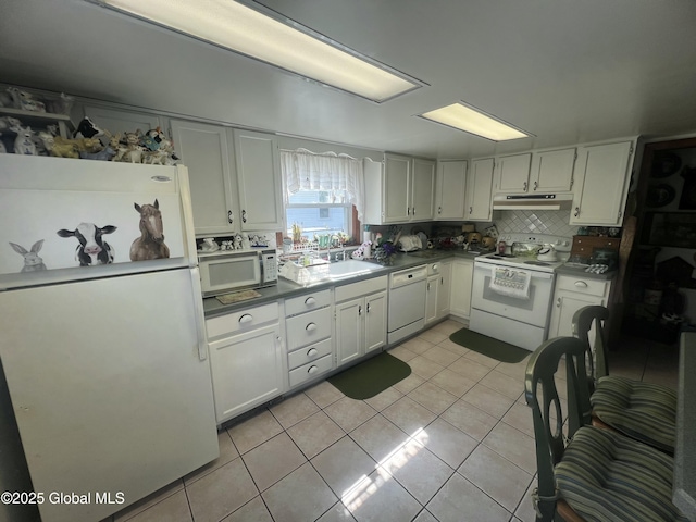 56 Wendell St, Ravena, NY 12143 - kitchen featuring white appliances, under cabinet range hood, light tile patterned flooring, and dark countertops