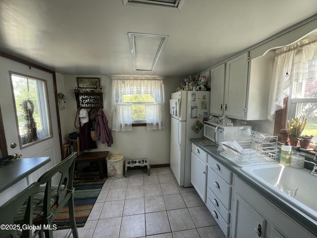 56 Wendell St, Ravena, NY 12143 - kitchen with white appliances, plenty of natural light, light tile patterned floors, and white cabinetry