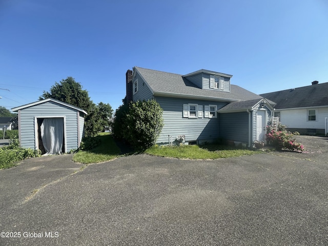56 Wendell St, Ravena, NY 12143 - view of front of property with a chimney, a shed, and roof with shingles