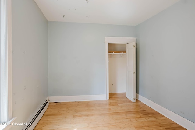 1818 4th St, Rensselaer, NY 12144 - unfurnished bedroom featuring baseboard heating, light wood-style floors, and a closet