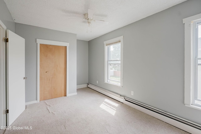 1818 4th St, Rensselaer, NY 12144 - unfurnished bedroom with a baseboard radiator, light carpet, multiple windows, and a textured ceiling