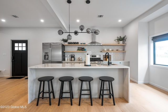 1 Wawayanda Pl, Middletown, NY 10940 - kitchen featuring appliances with stainless steel finishes, open shelves, backsplash, light wood-type flooring, and wall chimney range hood