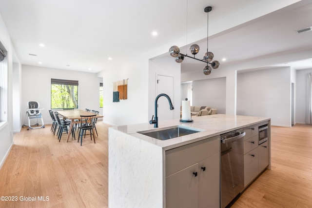 1 Wawayanda Pl, Middletown, NY 10940 - kitchen with stainless steel appliances, open floor plan, light wood-type flooring, light stone countertops, and a center island with sink