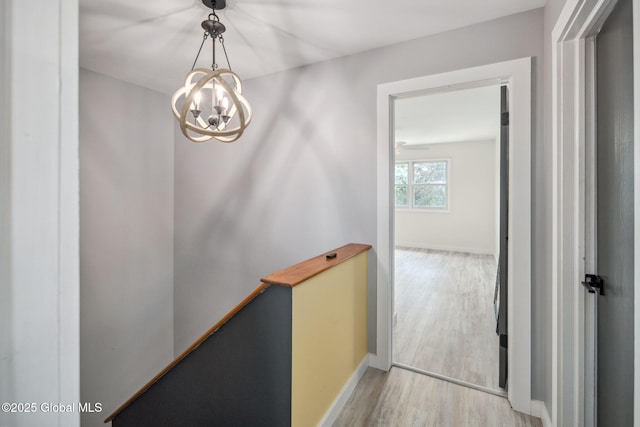 24 Esplande St, Bethlehem, NY 12158 - hallway with light wood-style floors, an upstairs landing, and a chandelier