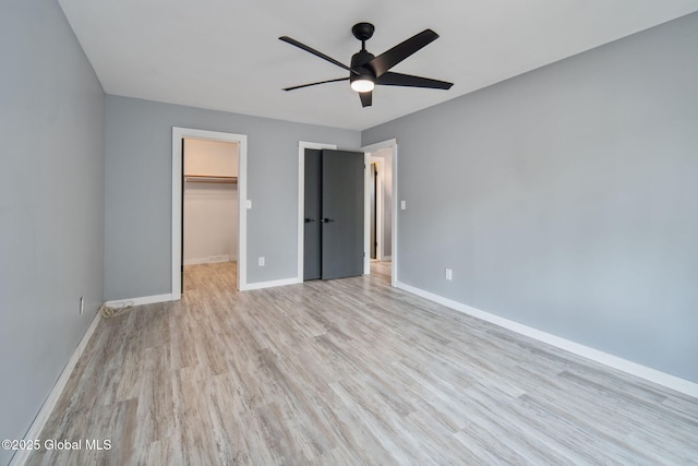24 Esplande St, Bethlehem, NY 12158 - unfurnished bedroom with light wood finished floors, a walk in closet, a closet, and a ceiling fan