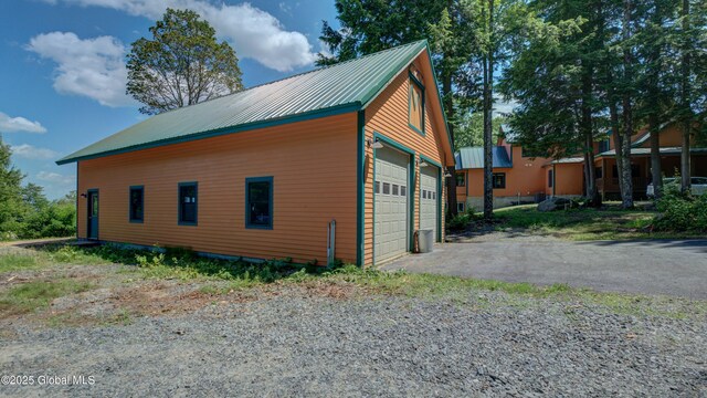 102 Taylor Ct, Mayfield, NY 12117 - view of property exterior featuring a metal roof, a detached garage, and an outbuilding