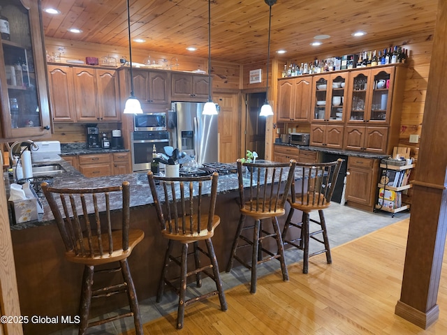 102 Taylor Ct, Mayfield, NY 12117 - kitchen featuring appliances with stainless steel finishes, light wood-style flooring, wooden ceiling, brown cabinetry, and glass insert cabinets