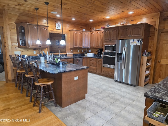 102 Taylor Ct, Mayfield, NY 12117 - kitchen with stainless steel appliances, a peninsula, dark stone countertops, glass insert cabinets, and a kitchen bar