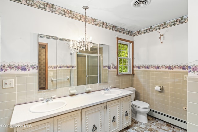 654 Birchwood Dr, Princetown, NY 12056 - bathroom with a baseboard heating unit, tile walls, double vanity, a stall shower, and a wainscoted wall