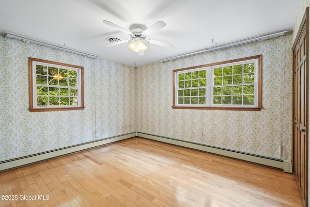 654 Birchwood Dr, Princetown, NY 12056 - empty room with plenty of natural light, light wood finished floors, baseboard heating, and wallpapered walls