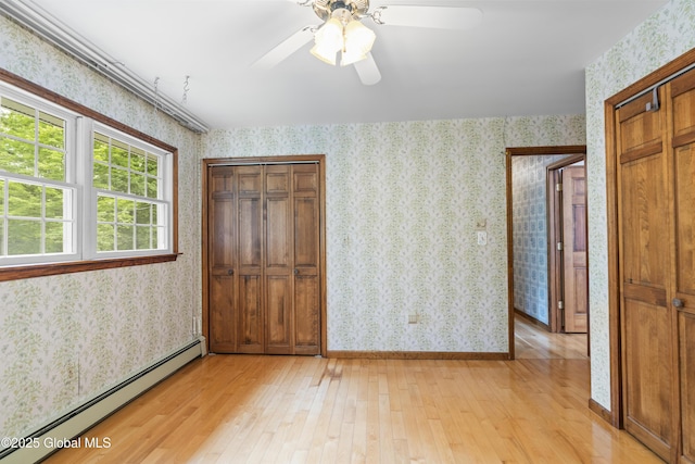654 Birchwood Dr, Princetown, NY 12056 - unfurnished bedroom featuring a baseboard heating unit, light wood finished floors, wallpapered walls, and a ceiling fan
