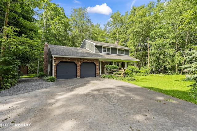 654 Birchwood Dr, Princetown, NY 12056 - traditional home featuring a chimney, an attached garage, driveway, a front lawn, and brick siding