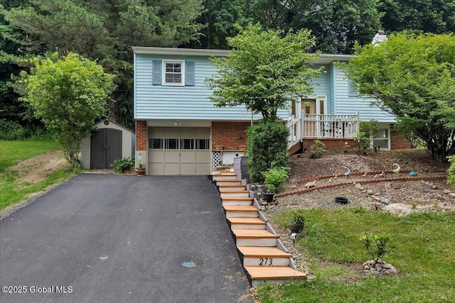 273 Pinehurst Ave, East Greenbush, NY 12144 - view of front facade with a shed, brick siding, asphalt driveway, a garage, and stairs