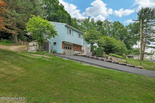 273 Pinehurst Ave, East Greenbush, NY 12144 - view of front of home with driveway, an attached garage, a front lawn, brick siding, and a shed
