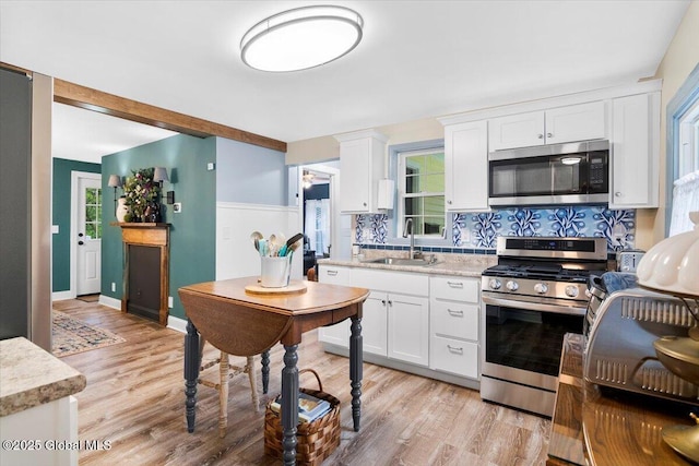 4 Mitchell Ave, Cambridge, NY 12816 - kitchen with appliances with stainless steel finishes, light wood-style floors, white cabinets, tasteful backsplash, and light stone counters