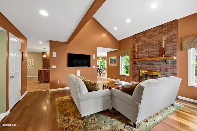 658 Salvia Ln, Guilderland, NY 12303 - living room with wood finished floors, a brick fireplace, high vaulted ceiling, and recessed lighting