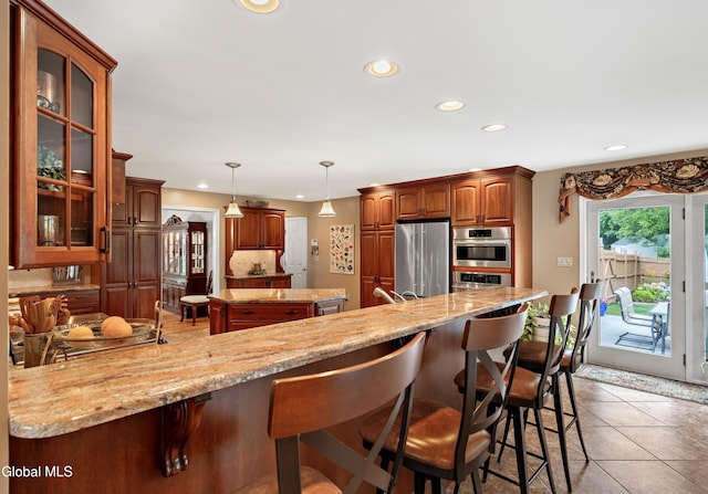658 Salvia Ln, Guilderland, NY 12303 - kitchen featuring stainless steel appliances, recessed lighting, a peninsula, a breakfast bar area, and glass insert cabinets