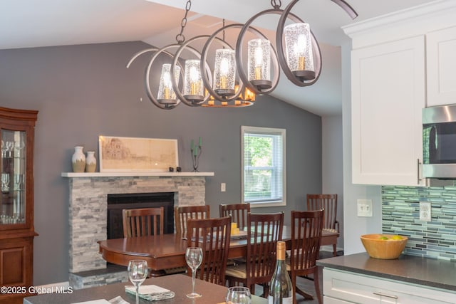 12 Heritage Ln, Clifton Park, NY 12065 - dining space featuring vaulted ceiling, a chandelier, and a fireplace