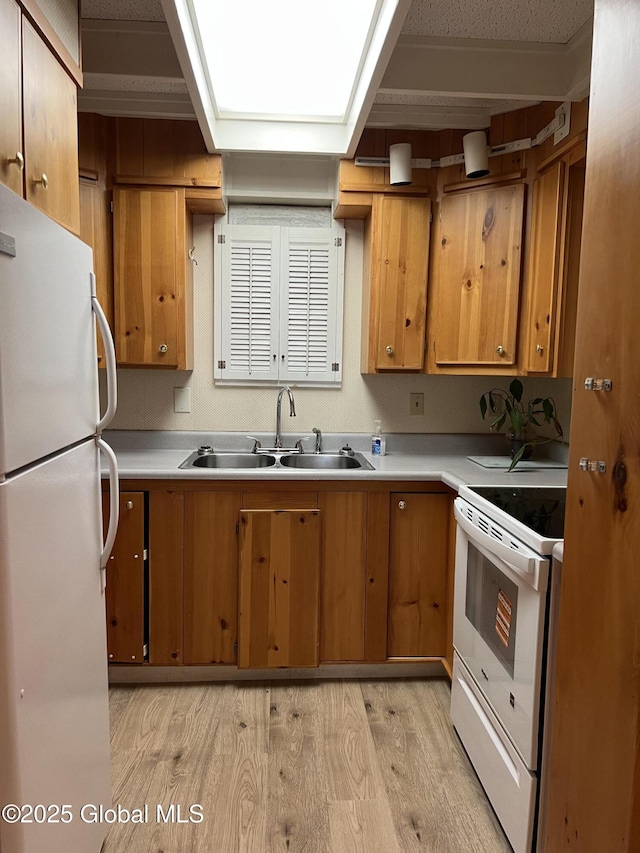 59 W St, Whitehall Village, NY 12887 - kitchen with white appliances, light wood finished floors, light countertops, a skylight, and brown cabinets