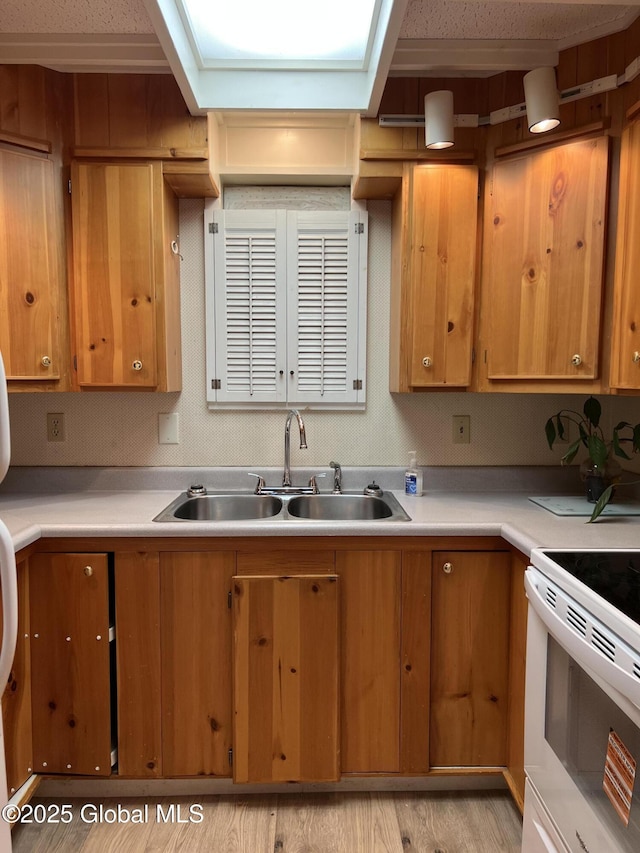 59 W St, Whitehall Village, NY 12887 - kitchen with electric range, light countertops, light wood-type flooring, and brown cabinetry