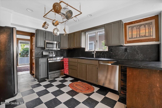 1280 Dean St, Niskayuna, NY 12309 - kitchen featuring appliances with stainless steel finishes, light floors, dark countertops, crown molding, and decorative backsplash