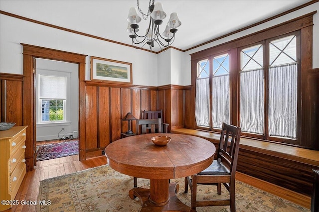 1280 Dean St, Niskayuna, NY 12309 - dining room with light wood finished floors, a chandelier, a wainscoted wall, and crown molding